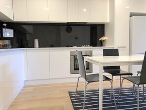 Apartamento, 2 quartos | Cozinha privada | Geladeira grande, micro-ondas, fogão, cooktop