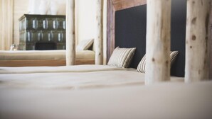 A bed with a wooden headboard, a bedside table with a lamp, and a nightstand with a lamp. - Der Hoferwirt (Neustift Im Stubaital)