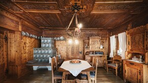 A wooden dining room with a table set for four, surrounded by chairs. - Der Hoferwirt (Neustift Im Stubaital)
