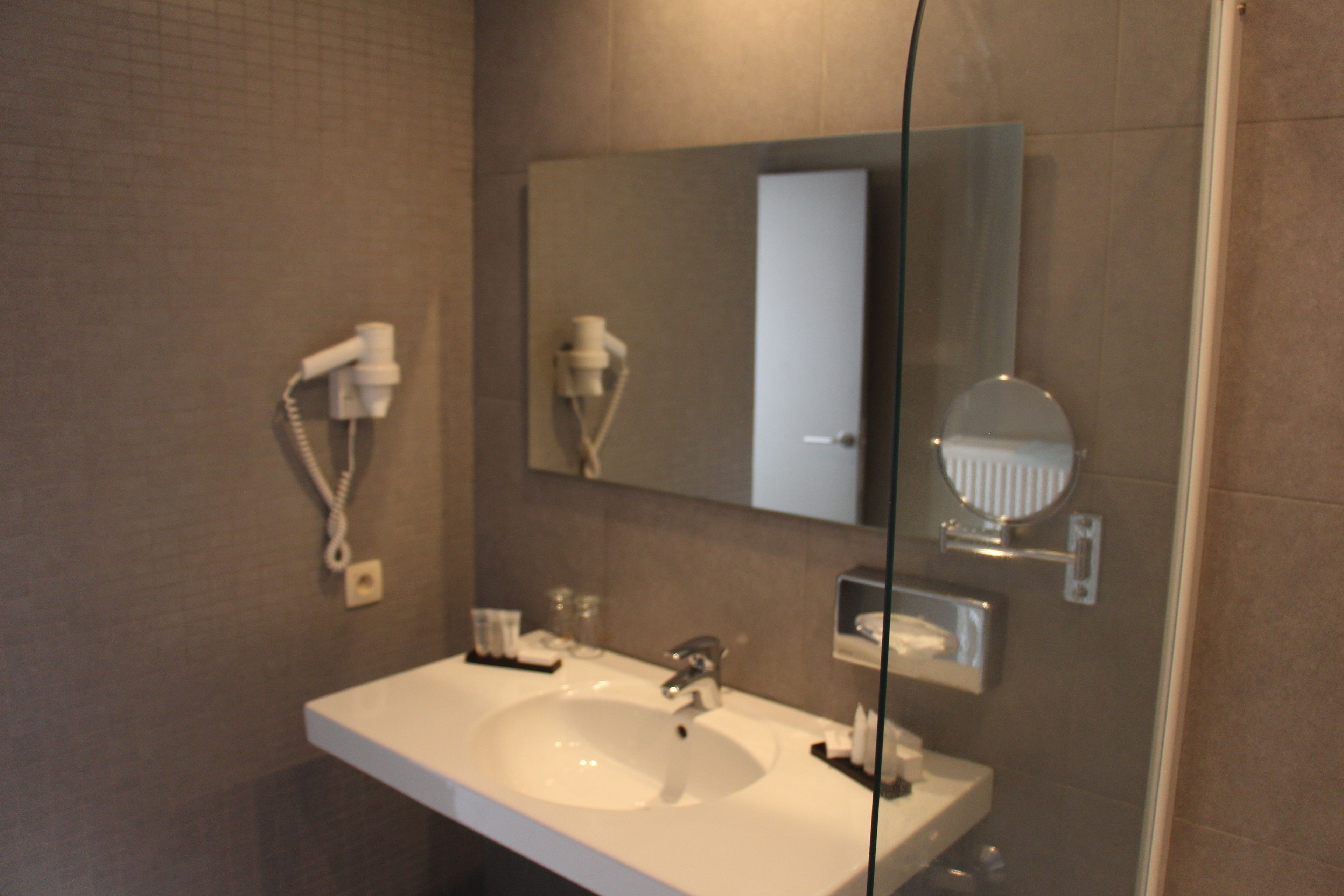 A bathroom with a white sink, a mirror, and a towel rack.
