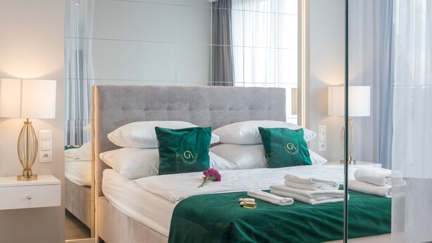 Una camera d'albergo moderna con un letto grande, un comodino, uno specchio e vista all'esterno.