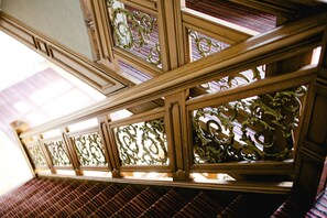 A wooden staircase with ornate metal railings and patterned floor tiles. - Hotel Villa Monte (Heist-op-den-Berg)