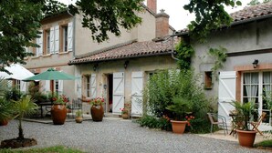 Ein Innenhof mit Kiesweg, Blumentöpfen und Gartenmöbeln.