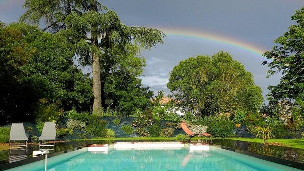 Ein Schwimmbad mit einem Regenbogen im Hintergrund.