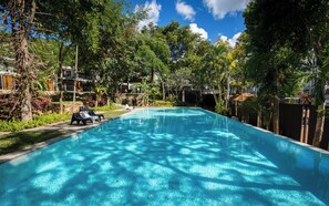 A rectangular swimming pool with clear blue water, surrounded by lush greenery and trees. - Lux 3 bedroom Villa Anagata - near fishing village (ko Samui)