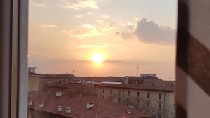 A sunset view from a window overlooking a cityscape with multiple buildings and rooftops. - Il Cantuccio B&B (Bologna)