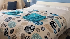 A hotel room with a bed, a chair, a wall clock, and a lamp. - Il Cantuccio B&B (Bologna)