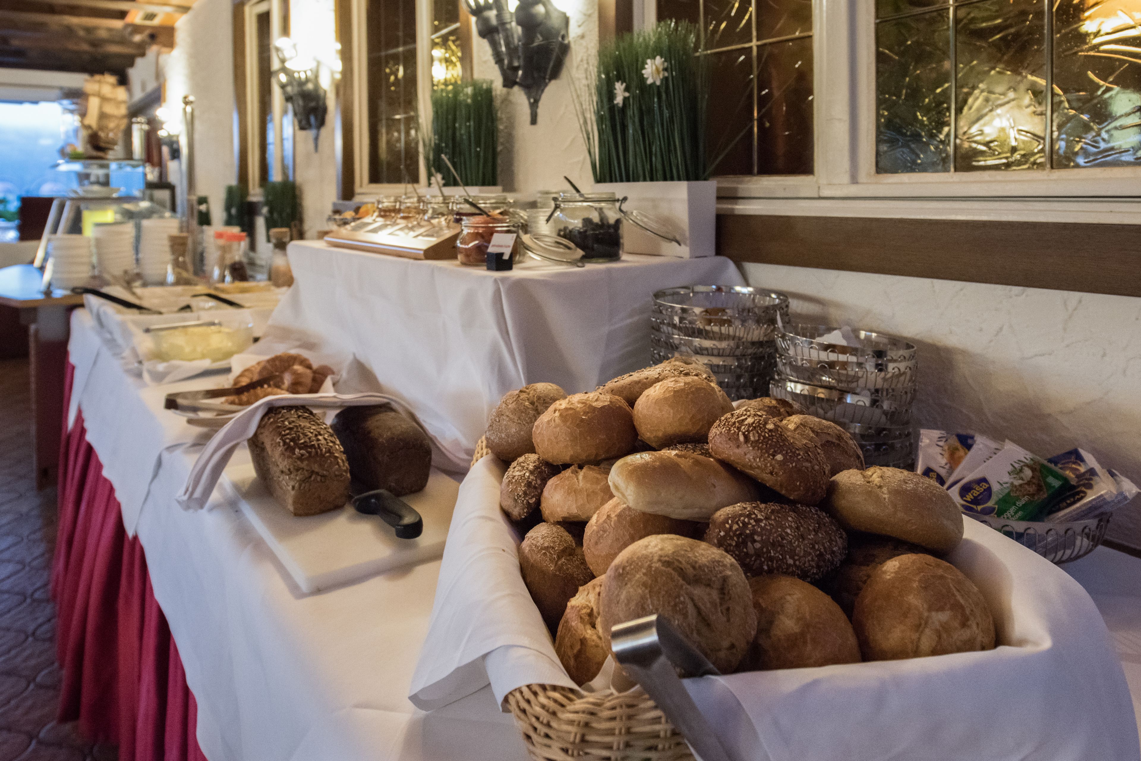 Une table de buffet proposant une variété de pains et de viennoiseries.