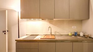 Una cocina con pileta, encimera y alacenas.