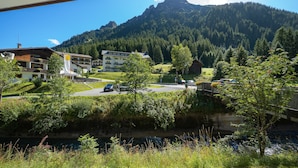 Un paisaje montañoso con un edificio en primer plano.