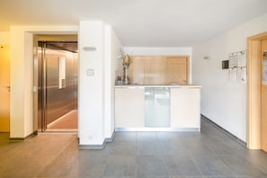 Experience the sleek, modern lobby with a central reception desk and contemporary elevator.