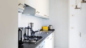 Una cocina moderna con electrodomésticos de acero inoxidable, estufa a gas y horno empotrado.