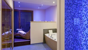 A compact bathroom with a bathtub, a shower area, and a small seating area with a window. - Dresalwoald (Gressoney-Saint-Jean)