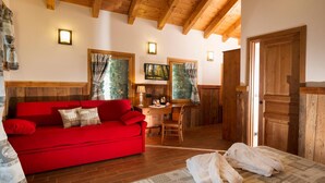 A cozy room with a red sofa, a wooden desk, and a bed with a patterned bedspread. - Dresalwoald (Gressoney-Saint-Jean)