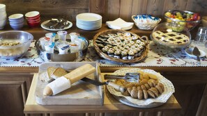 Een buffet met diverse soorten eten, zoals brood, koekjes en potten met sauzen.