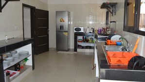 Una cocina moderna equipada con refrigerador, microondas, pileta y diversos utensilios de cocina.