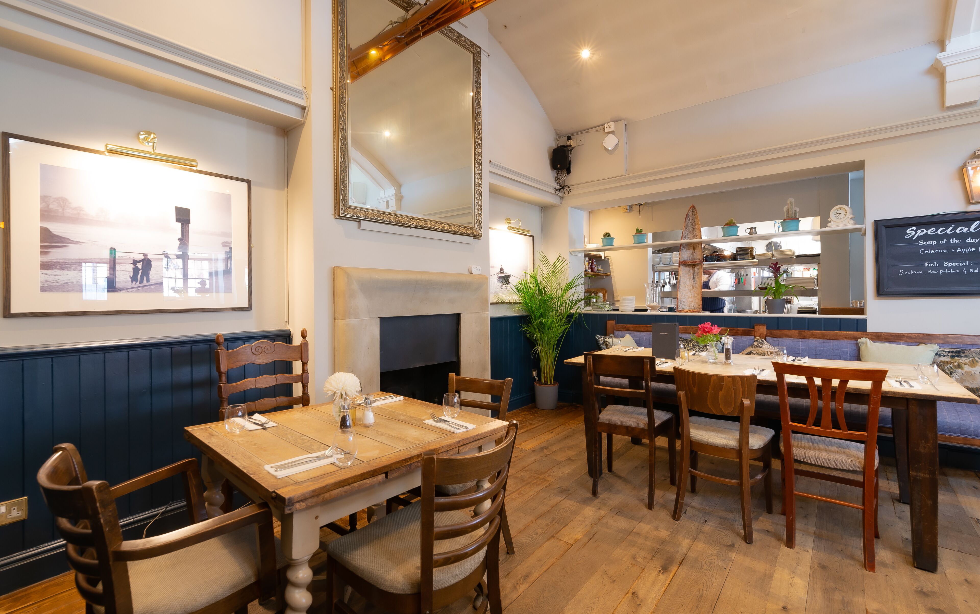 Un restaurante con muebles de madera, una chimenea y un tablero de menú en la pared.