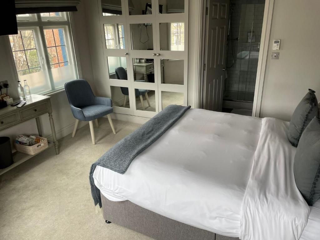 A bedroom with a bed, a desk, a chair, and a walk-in closet.