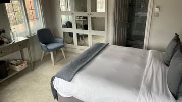 A bedroom with a bed, a desk, a chair, and a walk-in closet.