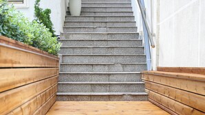 Una escalera de madera con una planta en maceta en la parte superior.
