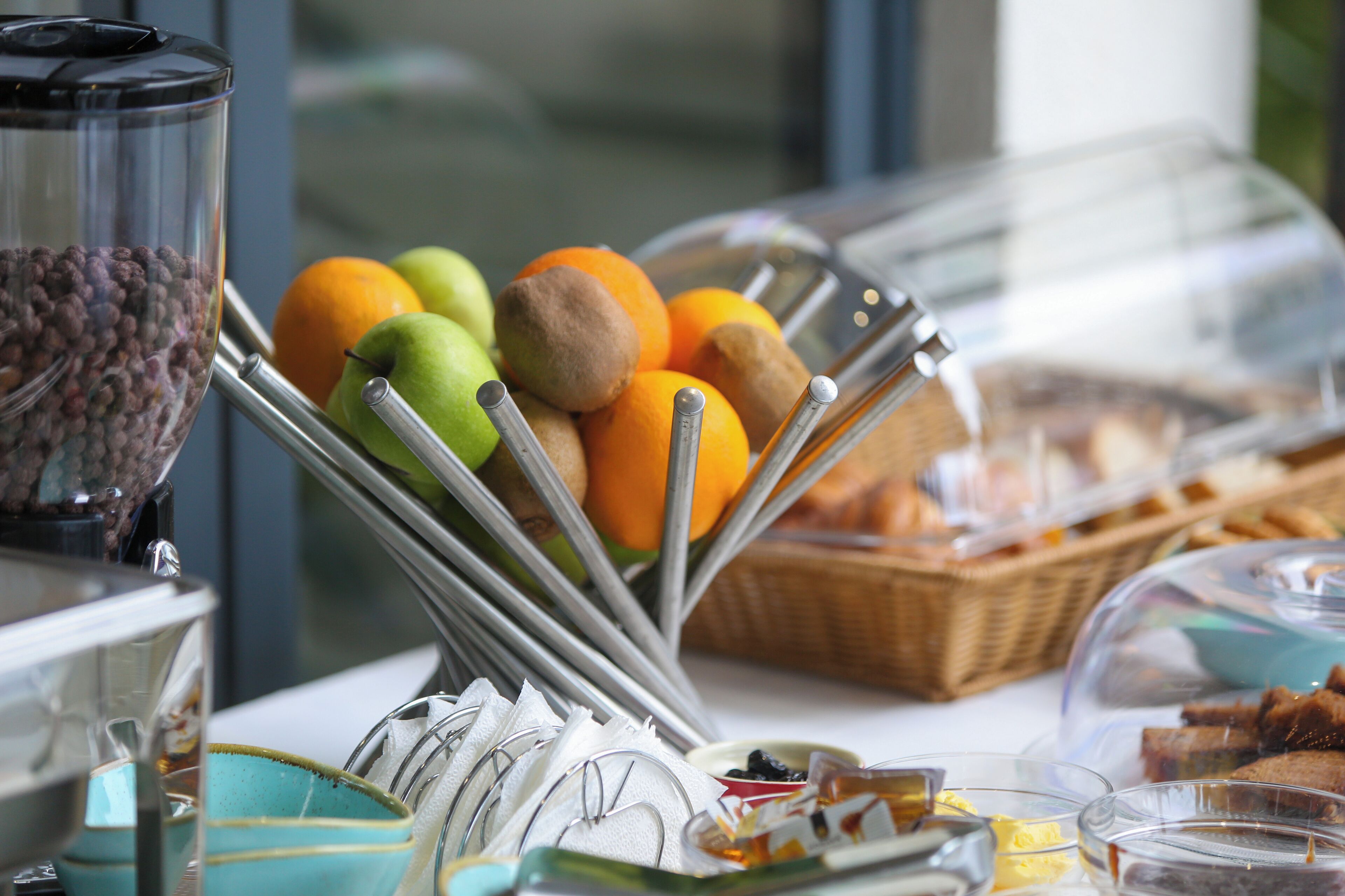 Un ricco buffet per la colazione con frutta, pane e diverse creme spalmabili.
