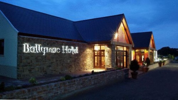A stone building with a sign reading "Ballymac Hotel" at night. - The Ballymac Hotel (Lisburn)