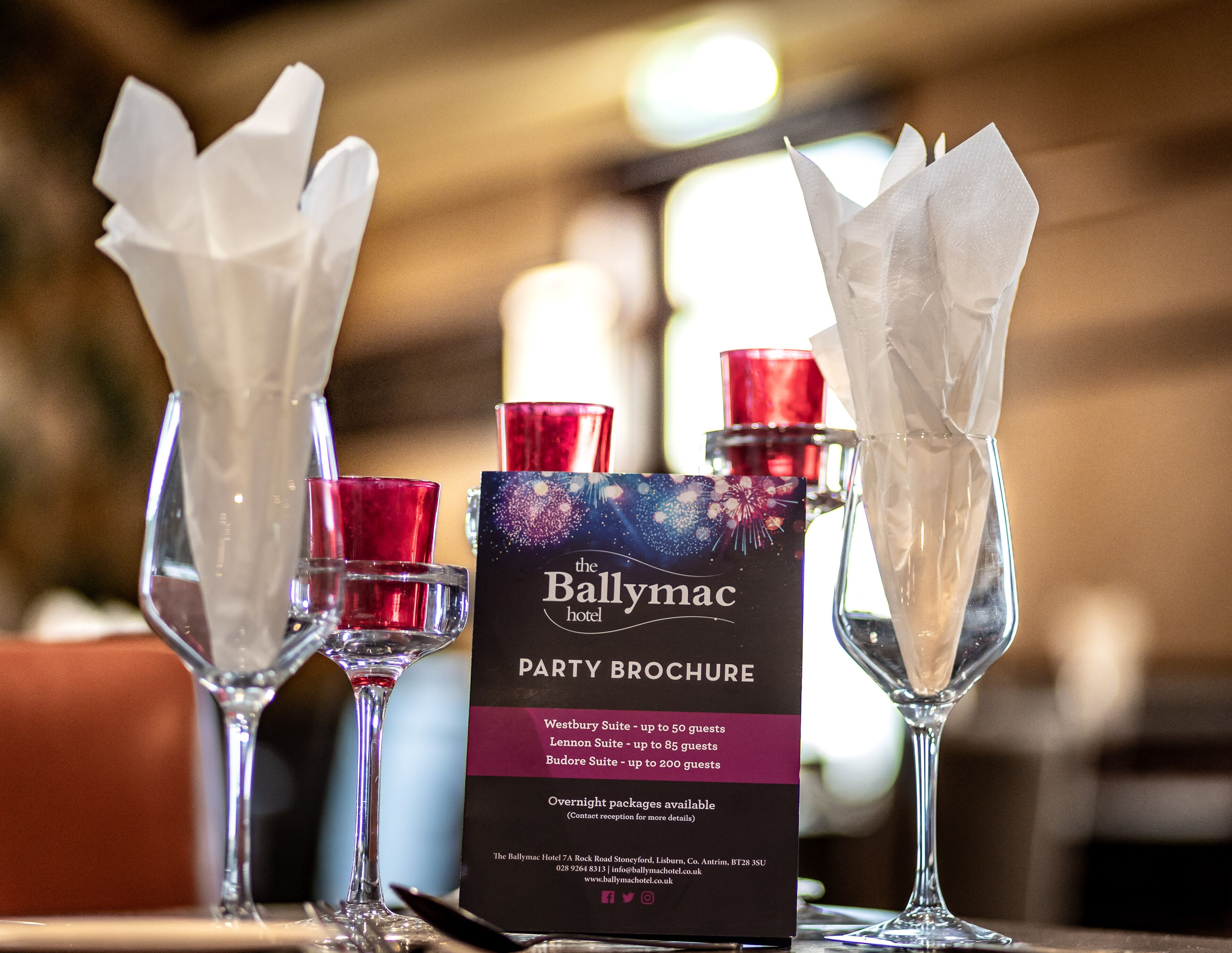 A table with a party brochure for The Ballymac Hotel, detailing suite capacities and overnight package availability.
