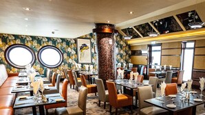 A restaurant with round tables, cushioned seating, and a patterned carpet. - The Ballymac Hotel (Lisburn)