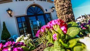 Welcome to our hotel, surrounded by lush gardens and a beautifully designed entrance.