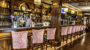 A bar area with a reception sign, bar stools, and a variety of bottles and glasses on shelves. - The Ballymac Hotel (Lisburn)