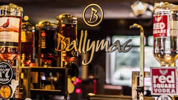 A bar with various bottles of alcohol, including 'The Famous Grouse' and 'Red Square Vodka'.