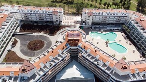 A modern hotel with a central courtyard, multiple swimming pools, and a landscaped garden. - Gara Suites Golf & SPA (Arona)