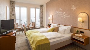 A hotel room with a bed, a TV, a desk, and a chair. - Waldhotel Wiesemann (Waldeck)