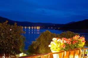 A night view of a lake with a bridge and trees in the foreground. - Waldhotel Wiesemann (Waldeck)