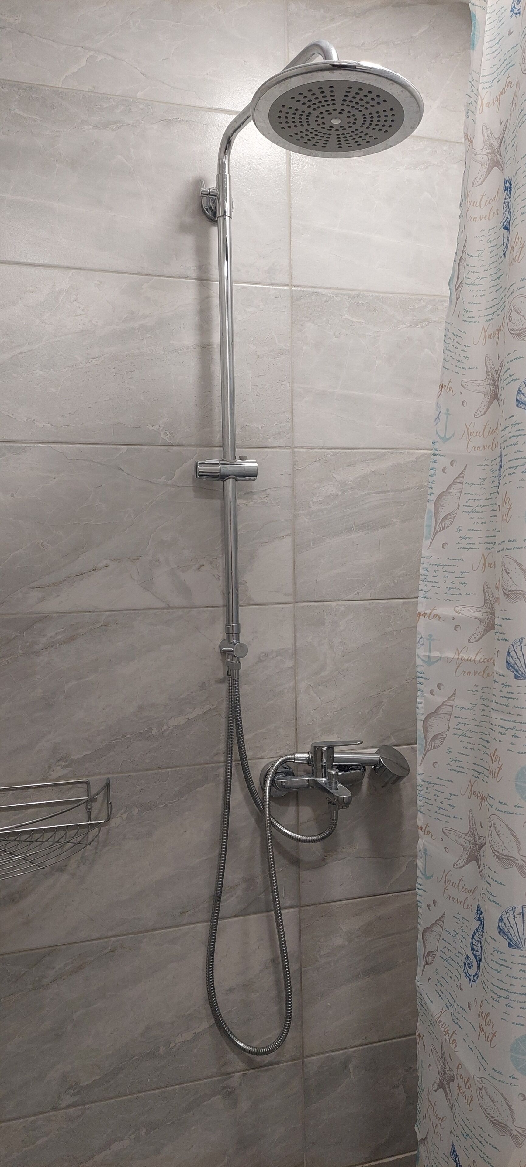 A shower with a handheld showerhead and a handheld faucet.