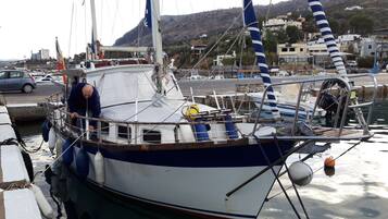 A boat docked at a marina with a cityscape in the background.
