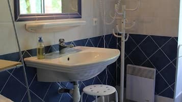 Ein Badezimmer mit Waschbecken, Spiegel und Dusche.