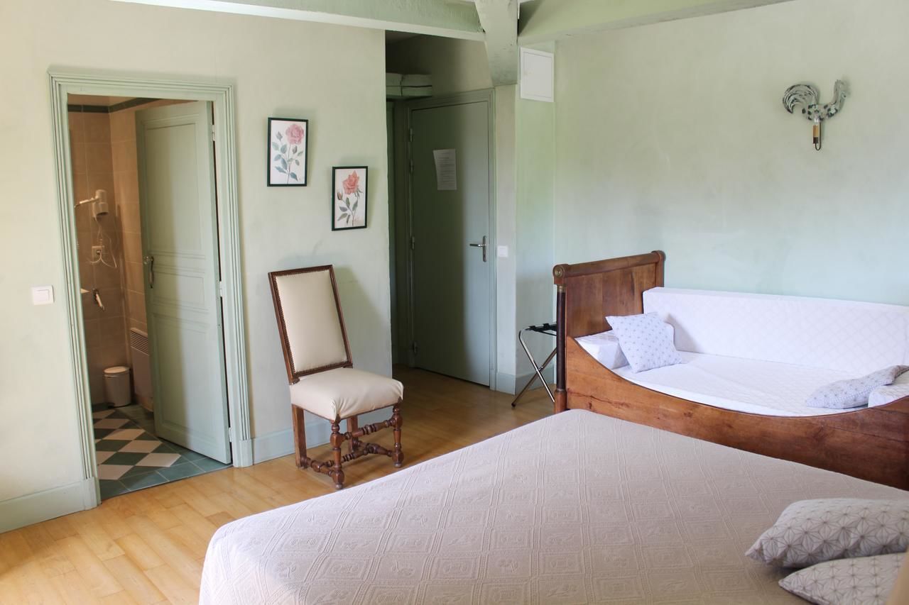 Un dormitorio con cama y silla de madera, y una puerta que da a un baño.