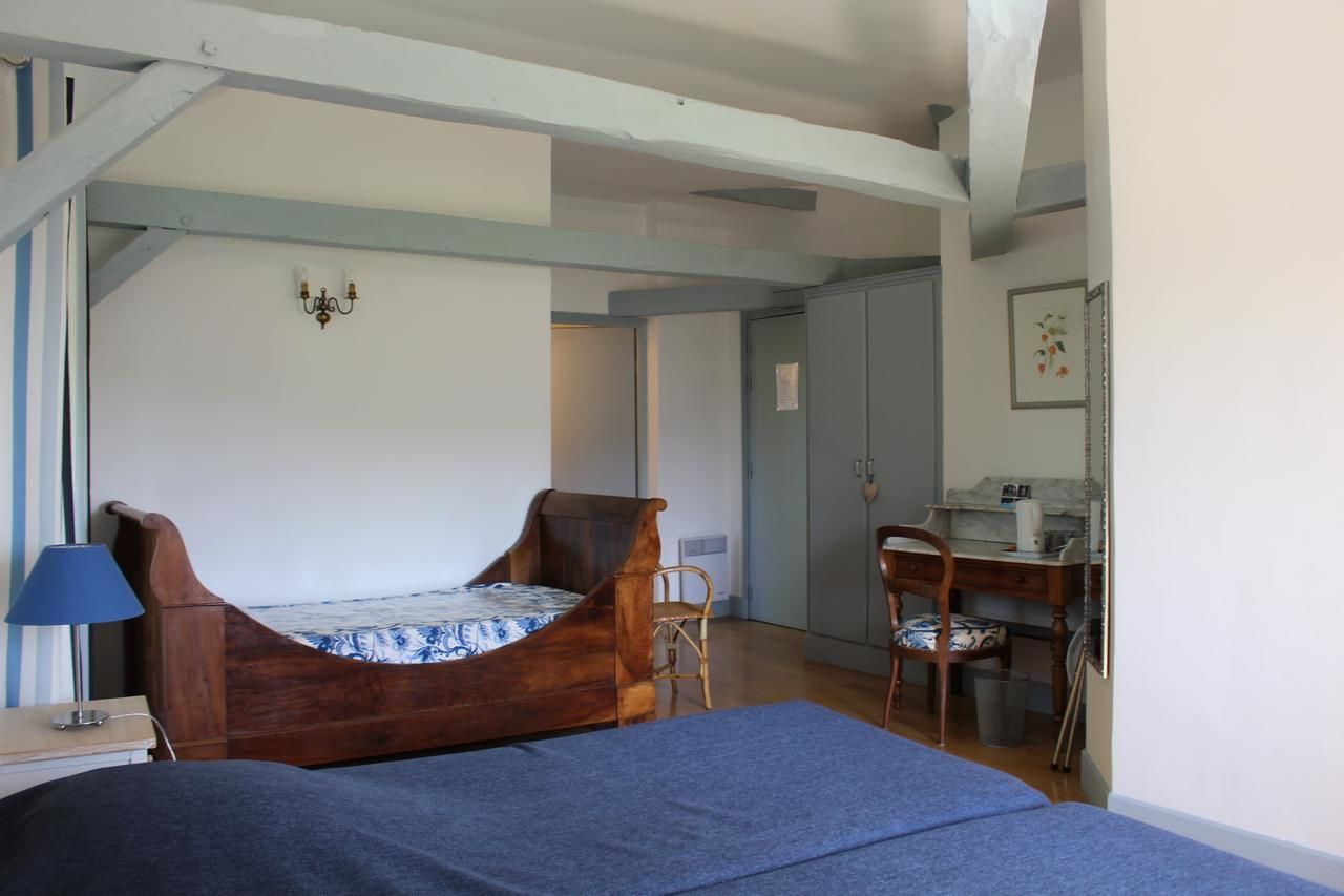 Quarto com cama de madeira, escrivaninha e cadeira.