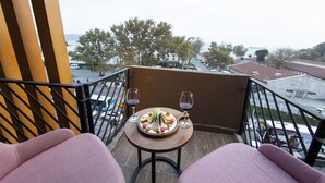 A balcony with a table set for two, featuring a plate of food and two wine glasses. - Meydan Besiktas Hotel (Istanbul)