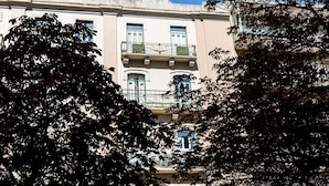 A multi-story building with balconies, large windows, and a clear blue sky. - Stay With Me Hostel (Lisbon)