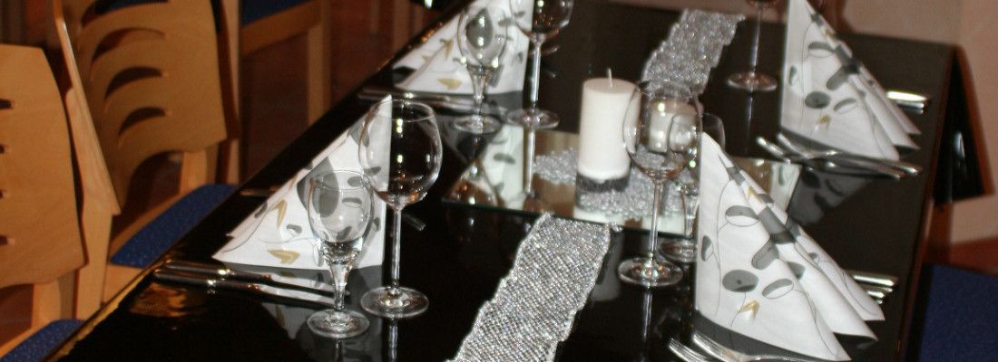 A table set for a formal event with multiple wine glasses, a candle, and silverware.
