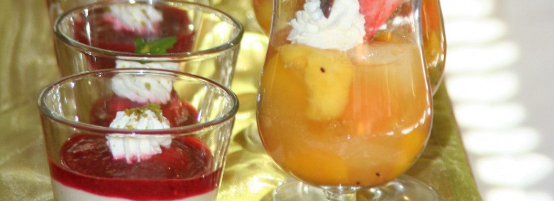 Tres vasos de postre con fruta y crema.