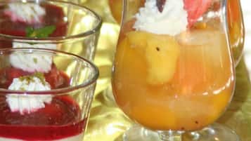 Tres vasos de postre con fruta y crema.
