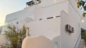 Un bâtiment blanc sur lequel on peut lire l’inscription : « Les Muses de Santorin ».