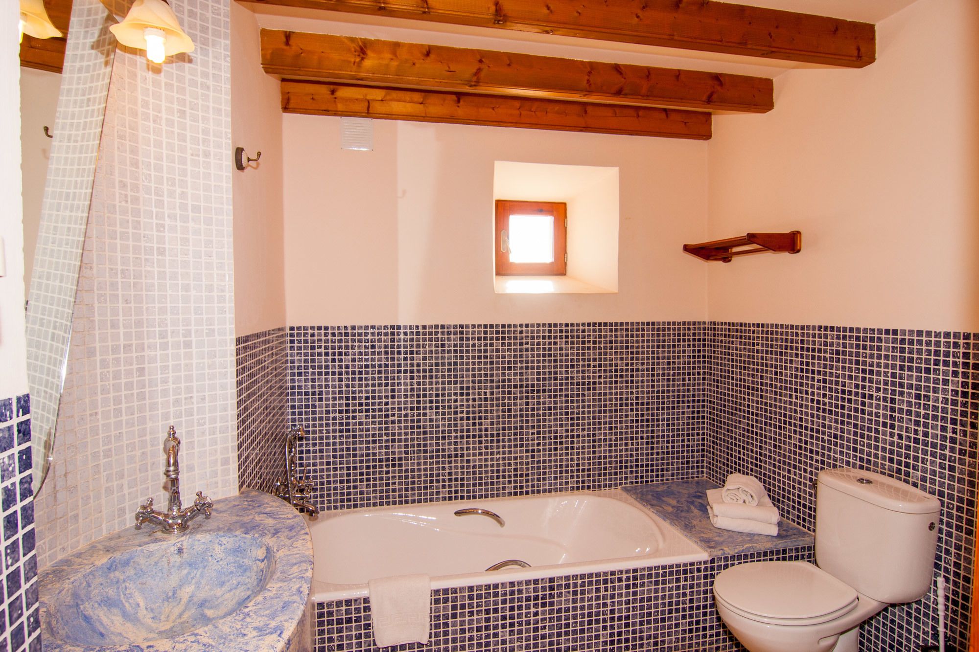 A bathroom with a marble sink, a bathtub, and a toilet.