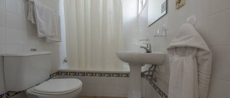 Een badkamer met toilet, bidet en wastafel.