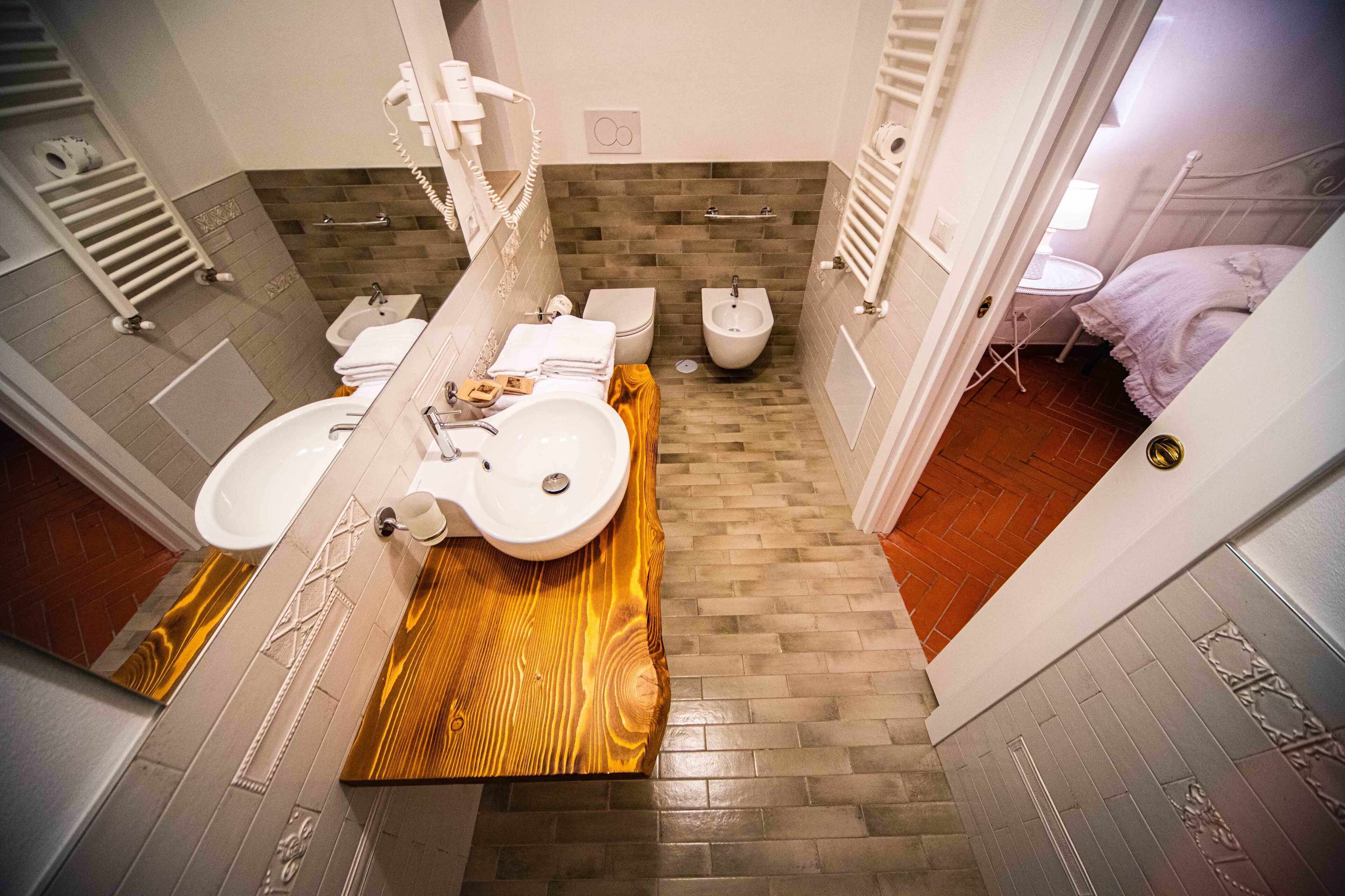 Un baño con dos lavamanos, un bidé y un inodoro.