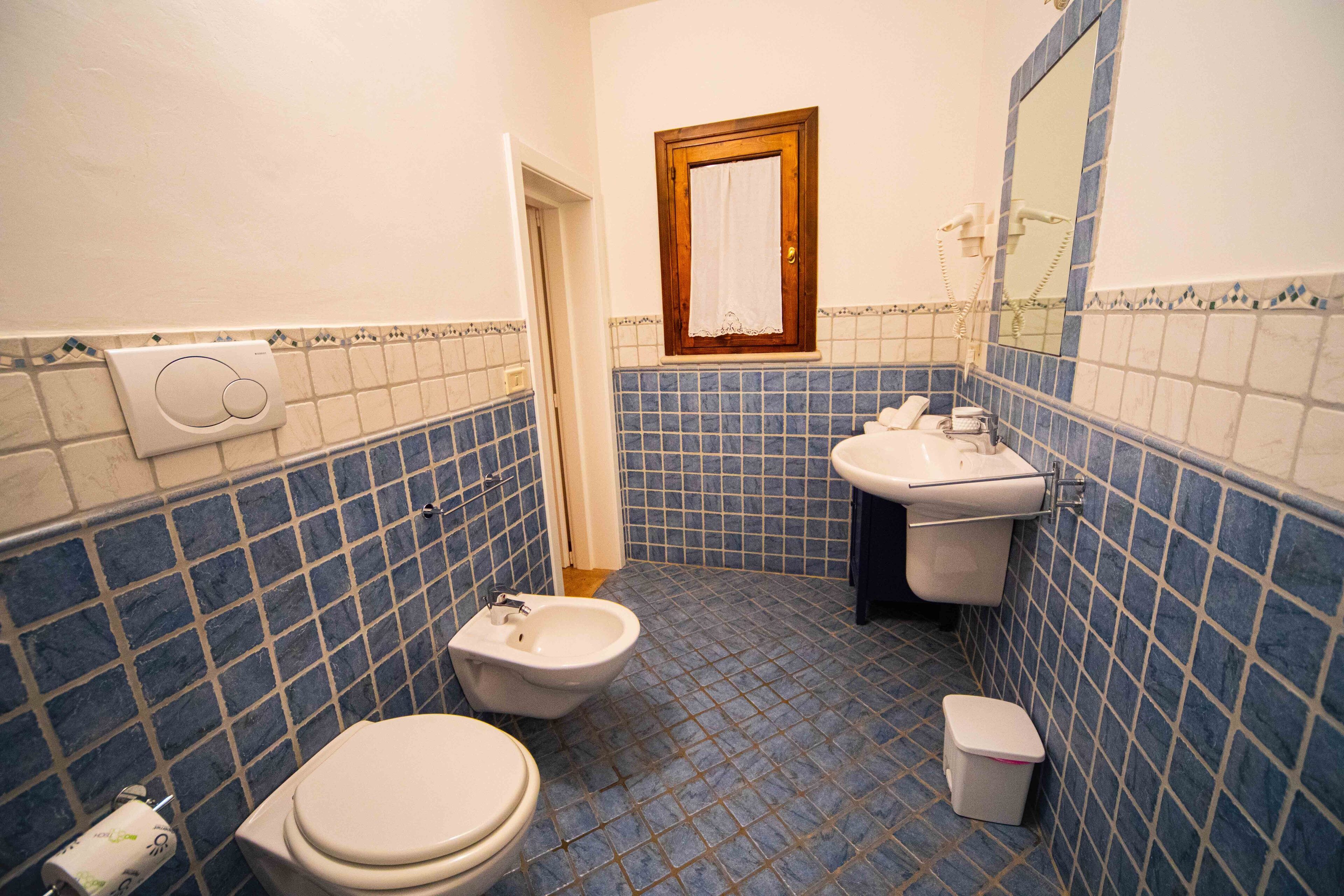 Ein Badezimmer mit Bidet, Toilette und Waschbecken.
