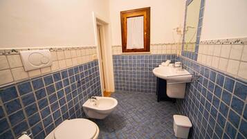 Ein Badezimmer mit Bidet, Toilette und Waschbecken.
